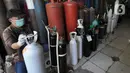 Pekerja mengisi ulang tabung gas oksigen di kawasan Ciputat, Tangerang Selatan, Banten, Senin (5/7/2021). Antrean terjadi seiring  peningkatan lonjakan korban positif COVID-19. (merdeka.com/Arie Basuki)