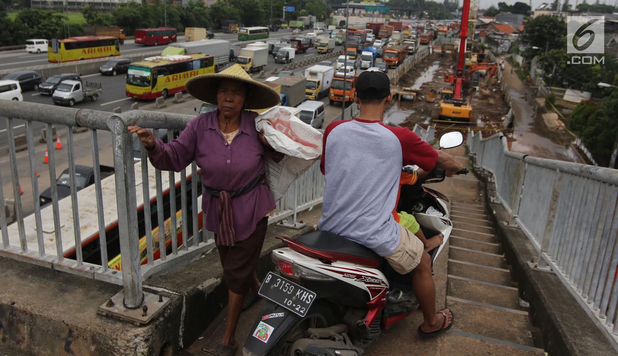 Pengendara motor melintas di samping pejalan kaki menuruni Jembatan Penyeberangan Orang (JPO) kawasan Cikunir, Bekasi Barat, Senin (12/3). Di jembatan ini pejalan kaki dan pemotor saling berebut melintas. (Liputan6.com/Arya Manggala)