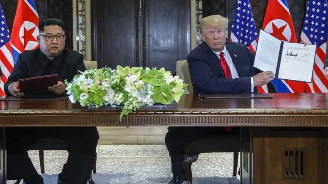 Donald Trump dan Kim Jong-un menandatangani perjanjian di Singapura. (AP/Evan Vucci)
