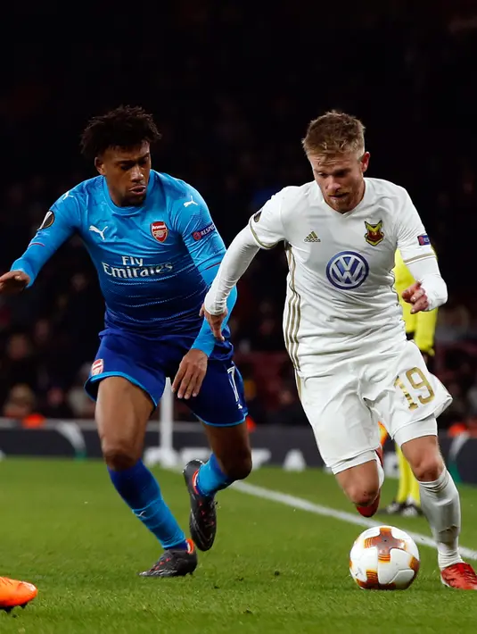 Pemain Arsenal, Alex Iwobi berebut bola dengan pemain  Ostersunds FK, Dennis Widgren pada laga leg kedua 32 Liga Europa 2017-2018 di Stadion Emirates, Kamis (22/2). Arsenal melaju ke babak 16 besar Liga Europa meski kalah 1-2. (AP/Alastair Grant)