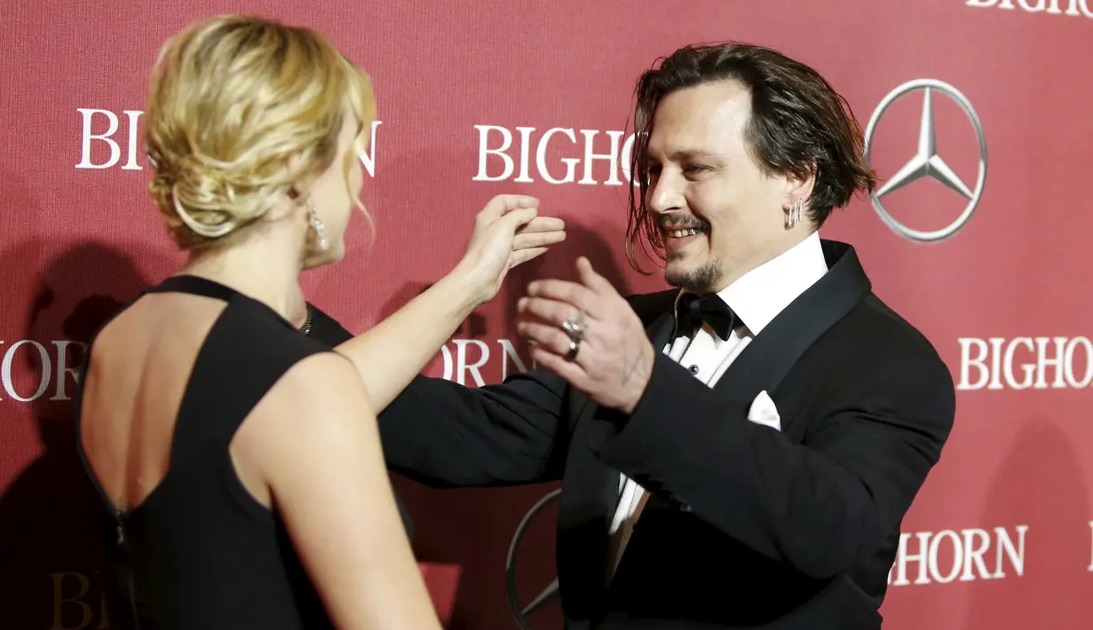Aktor Johnny Depp saat akan memeluk aktris Kate Winslet saat menghadiri Gala Annual Palm Springs International Film Festival Awards ke-27 di California, (2/1). Johnny Depp turut serta mengajak istrinya dalam acara ini. (REUTERS/Danny Moloshok)
