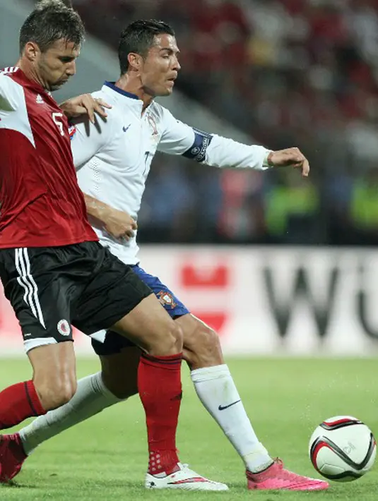 Cristiano Ronaldo berebut bola dengan pemain Albania, Lorik Cana dalam kualifikasi Euro 2016 di Elbasan Arena, Albania, Selasa (8/9/2015). Portugal menang 1-0 atas gol Miguel Veloso di saat injury time. (AFP Photo/Gent Shkullaku)
