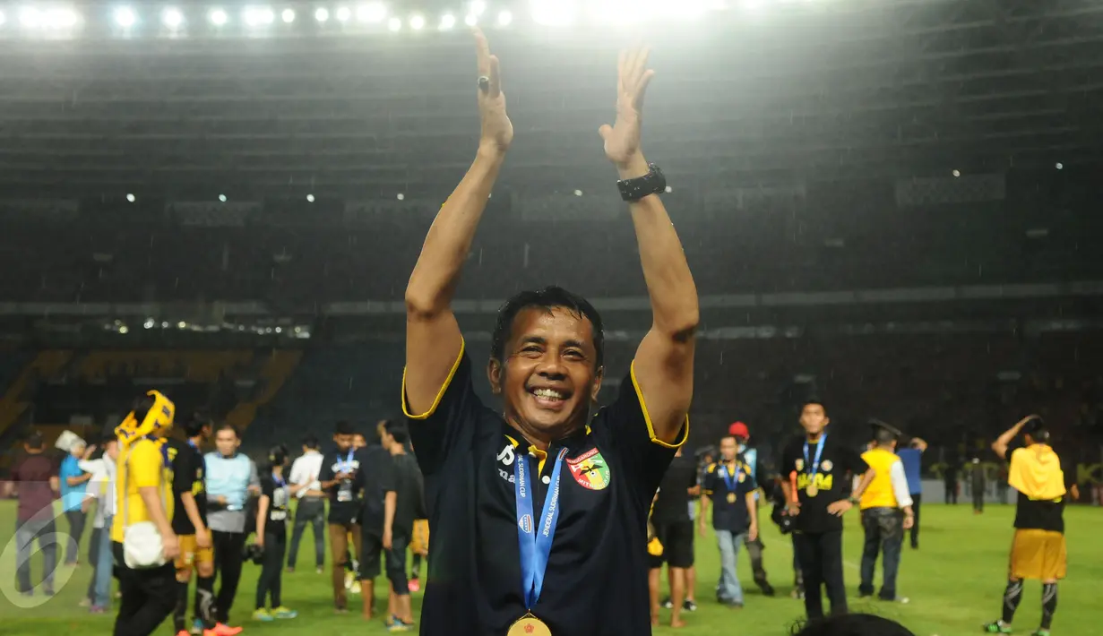 Pelatih Mitra Kukar, Jafri Sastra mengangkat tangan usai memastikan kemenangan atas Semen Padang pada final turnamen Piala Jenderal Sudirman, Minggu (24/1/2016). Mitra Kukar unggul 2-1 atas Semen Padang. (Liputan6.com/Helmi Fithriansyah)