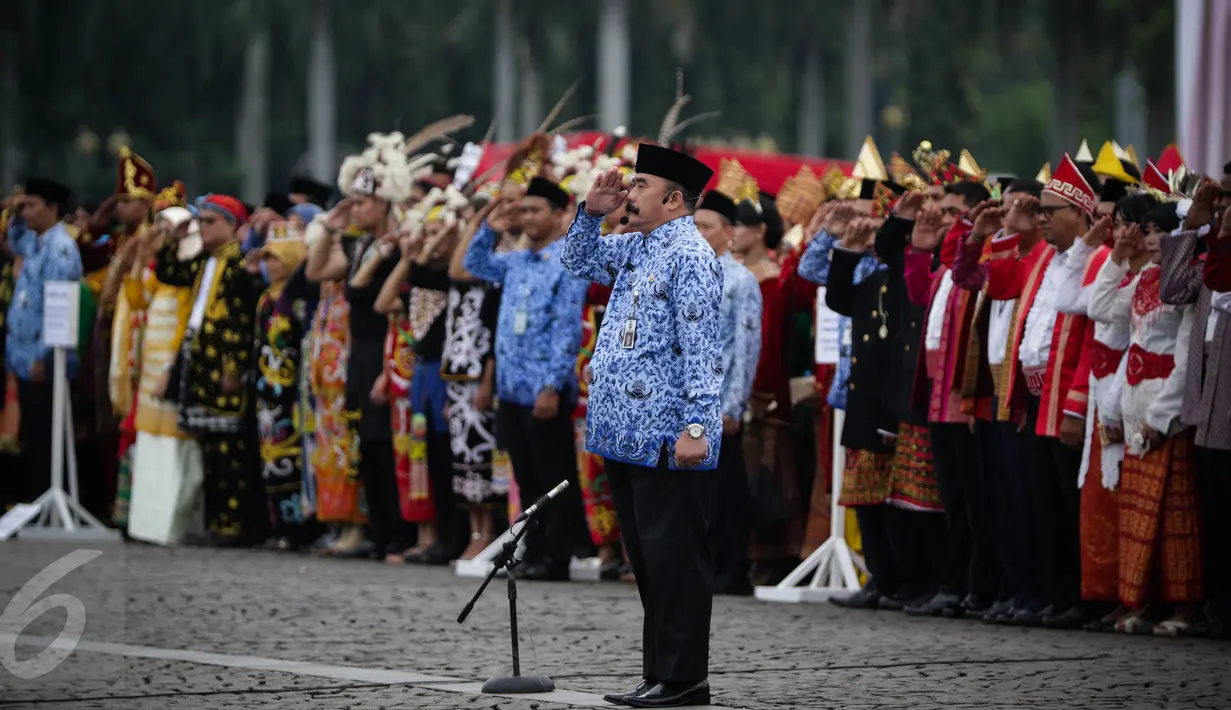 Peserta upacara memberi hormat kepada inspektur upacara peringatan HUT ke-45 Korps Pegawai Republik Indonesia (Korpri) di Silang Monas, Jakarta, Selasa (29/11). Peserta upacara yang mengenakan pakaian adat berbagai daerah. (Liputan6.com/Faizal Fanani)