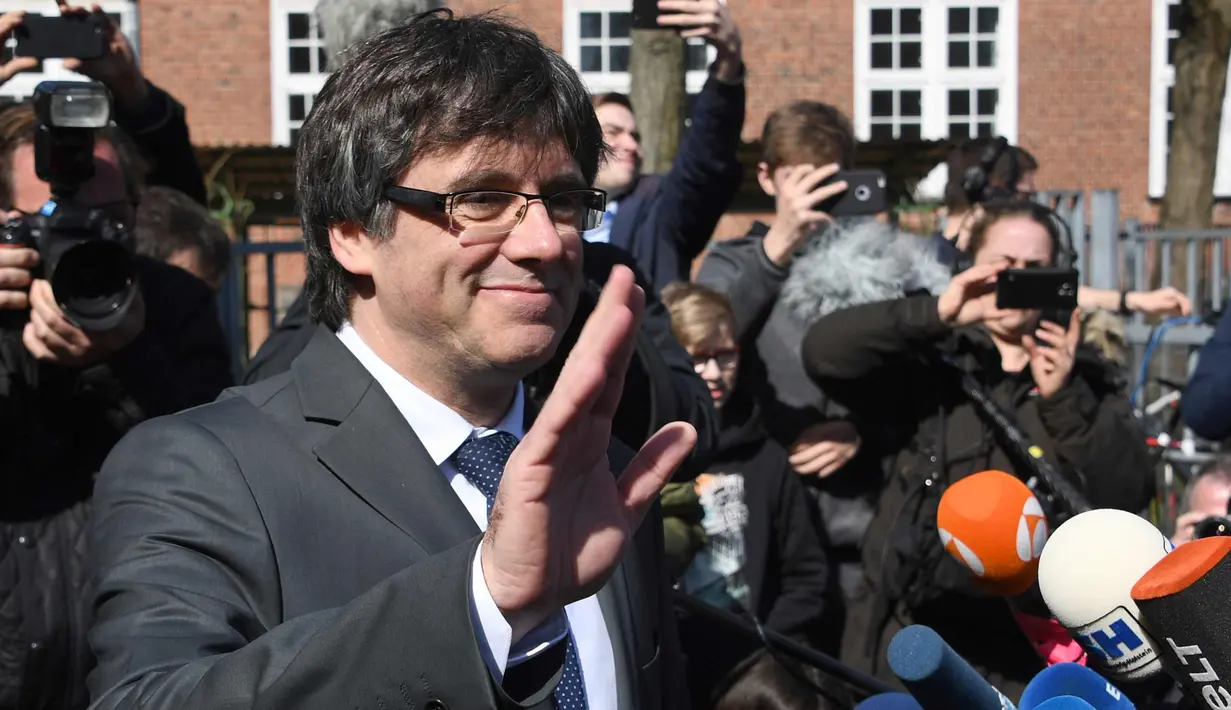 Mantan pemimpin Catalan, Carles Puigdemont menyapa awak media setelah dibebaskan di Neumuenster, Jerman, (6/4). Pria berusia 55 tahun itu dituntut atas tuduhan hasutan, pemberontakan dan penyalahgunaan dana publik di Spanyol. (Carsten Rehder/dpa via AP)
