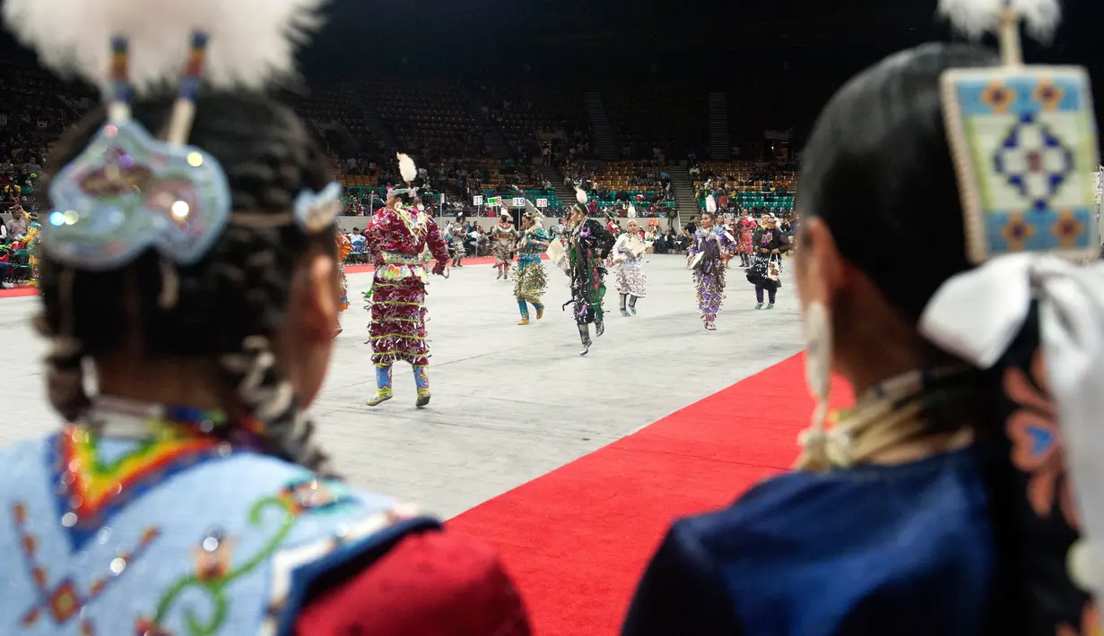 Para penari wanita asli Amerika menari saat mengikuti Grand Entry of the Denver March Powwow di Denver, Colorado (24/3). Acara ini juga menjadi ajang berkumpul dan bertemunya suku asli Amerika. (AFP/Jason Connolly)