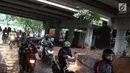 Pengendara motor melintasi jalan setapak di kolong tol di kawasan Lebak Bulus, Jakarta, Selasa (13/2). Untuk menghindari macet sebagian pengendara memanfaatkan jalan setapak tersebut untuk memersingkat waktu tempuh. (Liputan6.com/Immanuel Antonius)