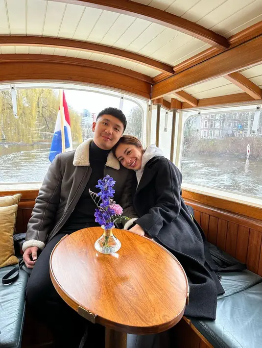 Pose mesra bersama suami, Nikita Willy tampak kece memadukan long coat dengan hoodie. [Foto: nikitawillyofficial94].