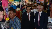 Presiden Indonesia Joko Widodo (kiri) dan Perdana Menteri Australia Malcolm Turnbull (tengah) berjabat tangan dengan pedagang saat blusukan di Blok A Pasar Tanah Abang, Jakarta, Kamis (12/11). (Liputan6.com/Faizal Fanani)