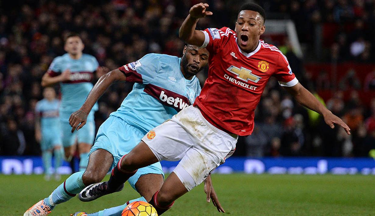 Pemain MU, Anthony Martial, menghindari tekel pemain West Ham, Alex Song pada laga Liga Premier Inggris di Stadion Old Trafford, Inggris, Sabtu (5/12/2015). (AFP Photo/Oli Scarff)