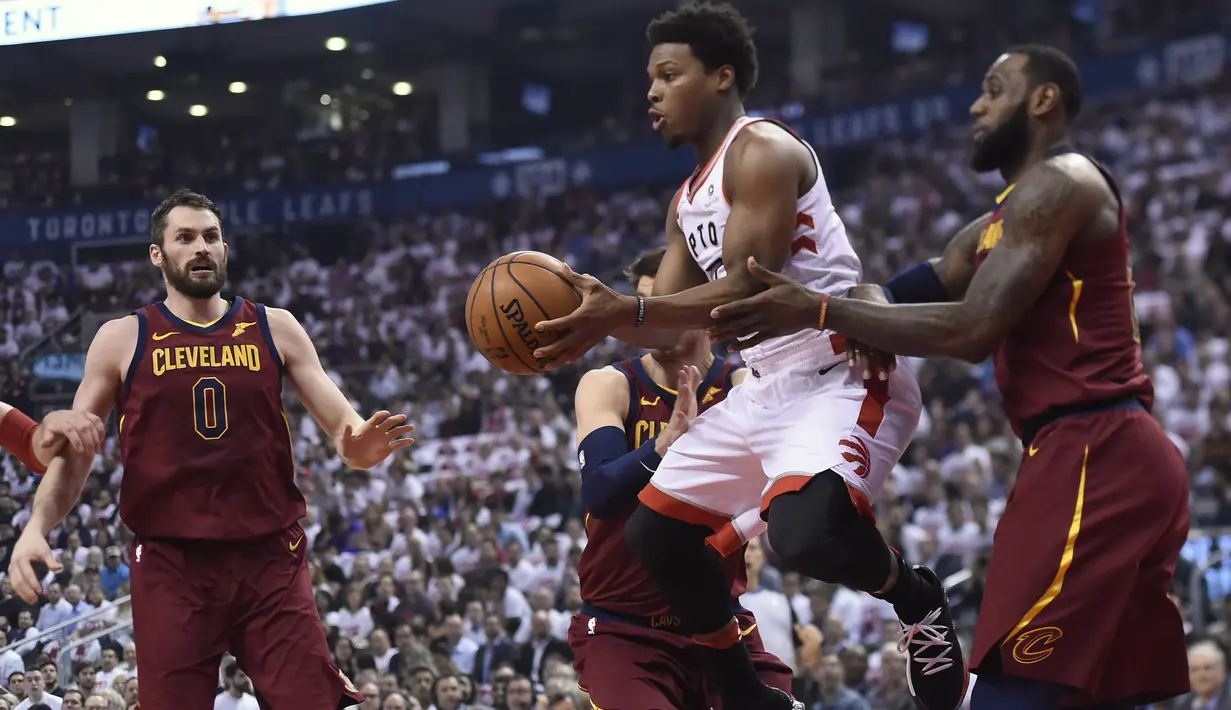 Pemain Raptors, Kyle Lowry (tengah) berusaha melewati adangan dua pemain Cleveland pada laga NBA basketball playoffs Eastern Conference semifinal di Air Canada Centre, (1/2/2018). Cavaliers menang 113-112. (Nathan Denette/The Canadian Press via AP)