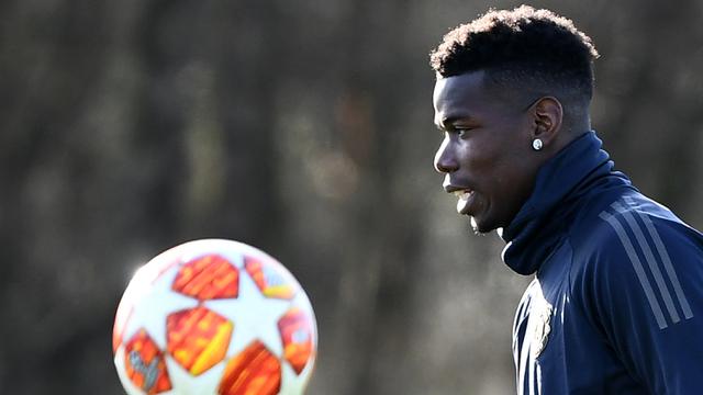 Pemain Manchester United, Paul Pogba, mengamati bola saat latihan jelang laga 16 besar Liga Champions. (AFP/Franck Fife)