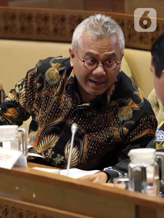 Ketua KPU Arief Budiman berbincang saat mengikuti rapat kerja dengan Komisi II DPR di Kompleks Parlemen Senayan, Jakarta, Selasa (14/1/2020). Rapat tersebut membahas Pilkada Serentak 2020 hingga kasus OTT yang menjerat Komisioner KPU Wahyu Setiawan. (Liputan6.com/Johan Tallo)