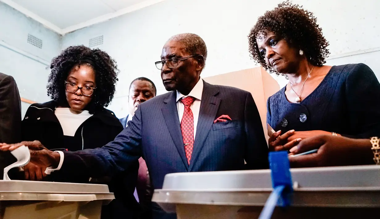 Mantan Presiden Zimbabwe, Robert Mugabe memasukan surat suara dalam pemilihan umum negara itu di TPS distrik Highfield, Harare, Senin (30/7). Mugabe pertama kalinya memberikan suara dalam pemilu, setelah dilengserkan November 2017. (AFP/ inyange AUNTONY)