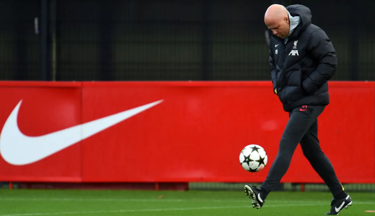 Pelatih Liverpool, Arne Slot melakukan juggling saat latihan jelang laga lanjutan Liga Champions 2024/2025 melawan Girona di AXA training centre, Liverpool, Inggris, Senin (09/12/2024) waktu setempat. (AFP/Peter Powell)
