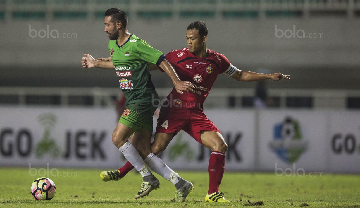 Striker PS TNI, Elio Martins, berusaha melewati bek Semen Padang, Handi Ramdhan, pada laga Liga 1 di Stadion Pakansari, Bogor, Minggu (30/7/2017). PS TNI menang 2-1 atas Semen Padang. (Bola.com/Vitalis Yogi Trisna)