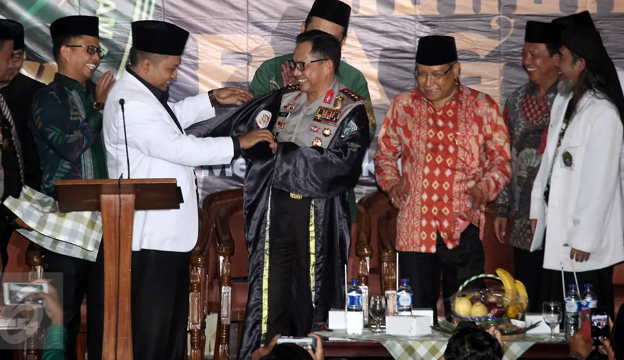 Sekjen Pagar Nusa M Nabil Haroen memberikan jubah kehormatan pencak silat Nahdlatul Ulama (PSNU) Pagar Nusa kepada Kapolri Jendral Tito Karnavian pada acara pembukaan Kongres III PSNU di TMII, Jakarta, Rabu (3/5). (Liputan6.com/Johan Tallo)