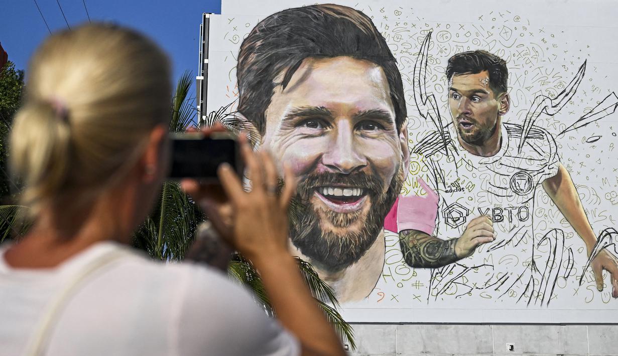 <p>Seorang wanita memotret mural besar bergambar Lionel Messi di Wynwood, Miami, 10 Juli 2023. La Pulga akan melakukan debutnya di Inter Miami pada 21 Juli di Piala Liga. (AFP/Chandan Khanna)</p>