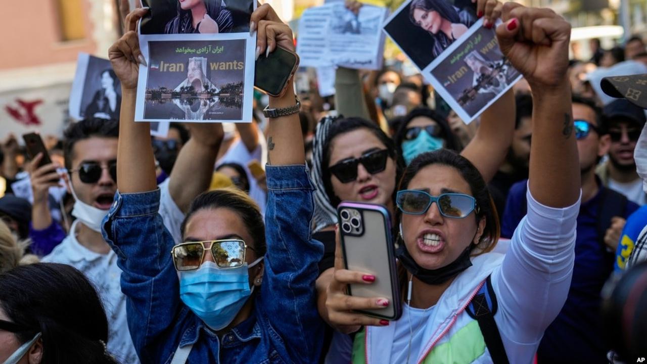 Wanita memegang foto Mahsa Amini dari Iran saat mereka meneriakkan slogan-slogan selama protes terhadap kematiannya, di luar konsulat jenderal Iran di Istanbul, Turki, 21 September 2022. (AP)