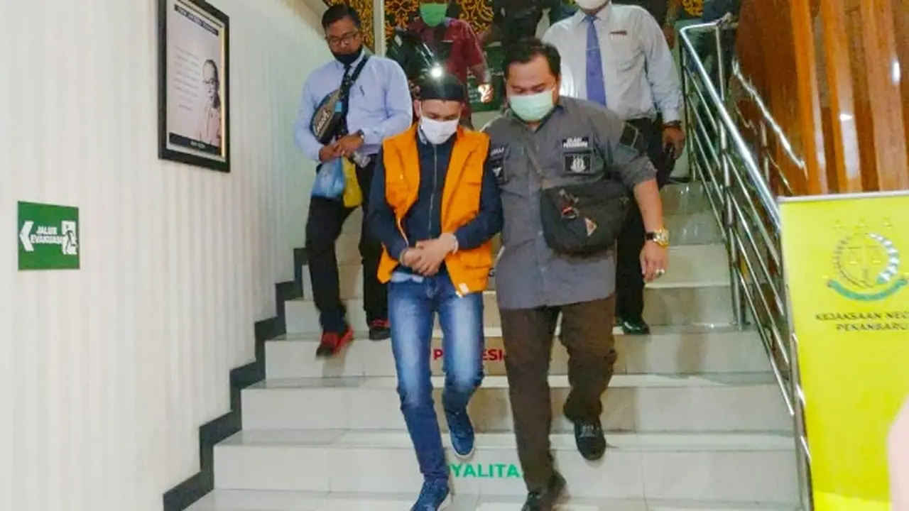 Petugas Kejari Pekanbaru ketika menggiring mantan Camat Tenayan Raya yang mernjadi tersangka korupsi dana kelurahan.