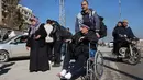 Diketahui, kedua kawasan tersebut diketahui mayoritas dihuni oleh warga etnis Kurdi. Tampak dalam foto, warga lingkungan Sheikh Maqsud dievakuasi dari zona berbahaya oleh anggota pasukan keamanan pemerintah Suriah, di Aleppo pada Sabtu 10 Januari 2026. (OMAR HAJ KADOUR/AFP)