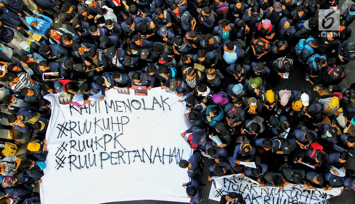 Mahasiswa membentangkan spanduk saat berunjuk rasa di depan Gedung DPR/MPR, Jakarta, Senin (23/9/2019). Dalam aksinya mereka menolak pengesahan RUU KUHP dan revisi UU KPK. (Liputan6.com/JohanTallo)
