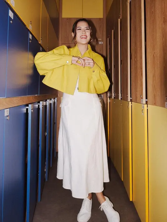 <p>Workwear dengan nuansa yang lebih kasual ala Raisa ini juga bisa ditiru. Dengan long dress putih polos, Raisa menambahkan cropped jacket bewarna kuning tua yang kontras, namun menarik, disempurnakan lagi dengan sneakers favorit. Foto: Instagram.</p>