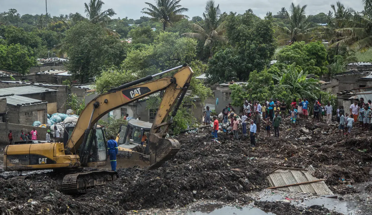Petugas menggunakan alat berat untuk melakukan proses evakuasi akibat longsornya gunung sampah di ibu kota Mozambik, Maputo,  Senin (19/2). Media lokal mengatakan timbunan sampah itu mencapai ketinggian gedung bertingkat tiga. (MAURO VOMBE / AFP)
