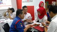 Karyawan Bank DKI menjelaskan aplikasi JakOne Mobile kepada pengunjung Pekan Raya Jakarta di Jakarta (23/5). JakOne Mobile dapat digunakan sebagai alat pembayaran pada merchant yang sudah bekerjasama. (Liputan6.com/Pool/Budi)