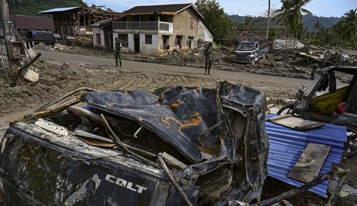Dua personel Tentara Nasional Indonesia (TNI) membantu pemulihan lingkungan di kawasan permukiman yang terdampak banjir bandang di Desa Aek Garoga, Tapanuli Selatan, Sumatera Utara, pada Sabtu 27 Desember 2025. Upaya pemulihan pasca bencana di Desa Garoga, Kecamatan Batang Toru, Tapanuli Selatan, Sumatera Utara, terus berlangsung. (YT Hariono /AFP)