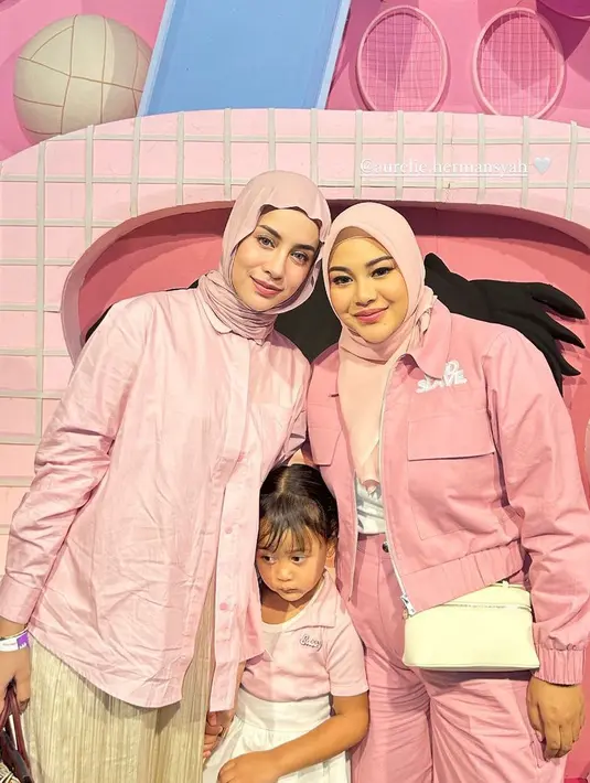 Influencer Aghnia hadir dengan putrinya, ia mengenakan kemeja pink serasi dengan kerudungnya, dipadukan bawahan plisket coklat. [@aghnia]