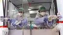 Petugas bersiap untuk mengambil sampel usap tenggorokan dan hidung dari dalam unit medis keliling saat uji virus corona COVID-19 bagi pekerja perhotelan dan pariwisata di Jalan Khao San, Bangkok, Thailand, Kamis (6/1/2022). (Jack TAYLOR/AFP)