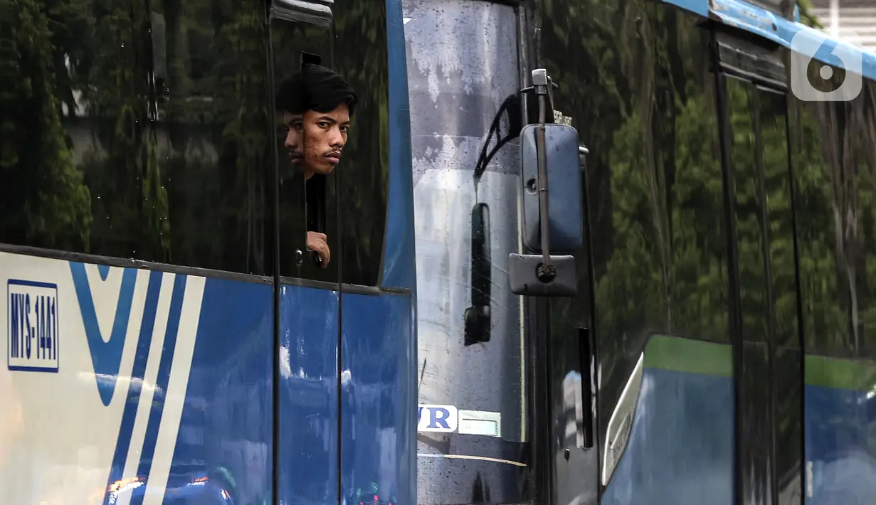 Warga melihat keluar dari bus di kawasan Blok-M, Jakarta, Senin (14/3/2022). Menurut Jubir Pemerintah untuk Penanganan COVID-19 Reisa Broto Asmoro, peralihan pandemi ke endemi tak bisa lepas dari jumlah kasus harian dan angka kematian rendah serta tingkat keterisian RS. (Liputan6.com/Johan Tallo)