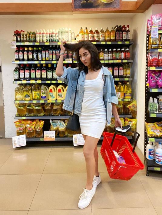 Memakai simpel dress putih serta sneakers berwarna senada, Naomi Zaskia memilih untuk menggunakan jaket jeans. Dirinya menggunakan sling bag hitam yang cukup simpel sebagai tambahan pada gaya OOTD. (Liputan6.com/IG/@naonomnom)