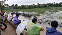 Warga Tampak Asyik Menghabiskan Waktu dengan Memancing Ikan di Sebuah Sawah yang Terendam Banjir, Belakang Telaga Nirwana Residence, Rawa Lumbu, Bekasi Timur, Jawa Barat, Rabu (1/1/2020). (Foto: Fachrur Rozie/Liputan6.com)