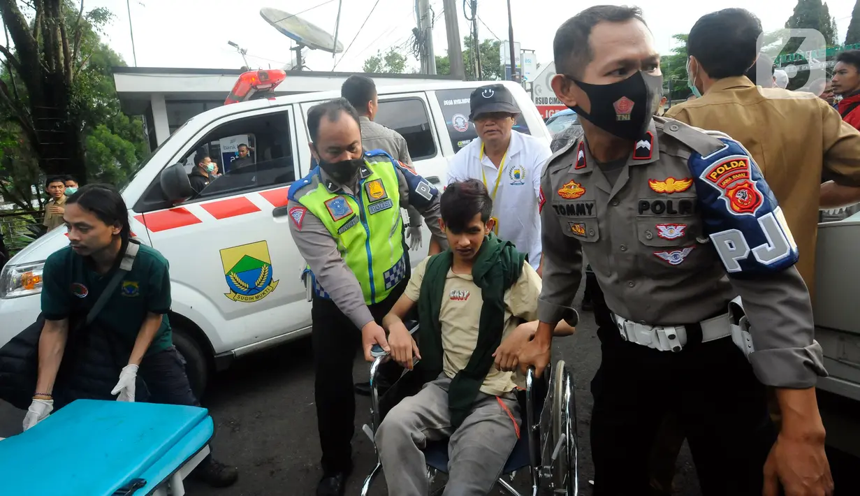 <p>Polisi membawa seorang korban gempa menggunakan kursi roda di RSUD Cimacan, Cianjur, Jawa Barat, Senin (21/11/2022). Hingga berita ini ditulis, Bupati Cianjur Herman Suherman menyebut jumlah korban meninggal akibat gempa magnitudo 5,6 yang mengguncang Cianjur sudah mencapai 56 orang dan 700 lebih lainnya luka-luka. (merdeka.com/Arie Basuki)</p>