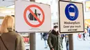 Para pejalan kaki berjalan melewati tanda yang mengingatkan warga untuk memakai masker dan larangan mengonsumsi alkohol di Munich, Jerman (11/12/2020). Kasus penularan dan kematian harian COVID-19 di Jerman terus meningkat dan mencapai rekor tertinggi baru. (Xinhua/Philippe Ruiz)