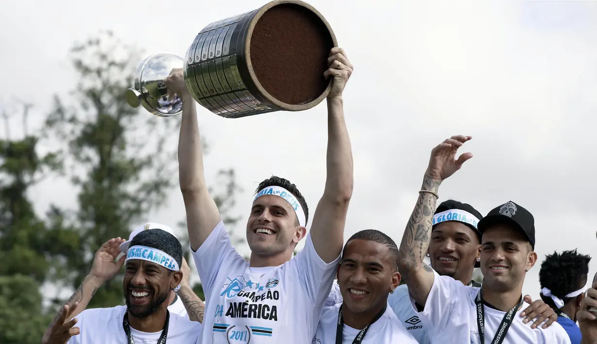 Kiper Gremio, Marcelo Grohe, mengangkat piala Copa Libertadores saat pawai di Porto Alegre, Brasil, Kamis (30/11/2017). Gremio menjadi juara Copa Libertadores setelah mengalahkan Lanus dengan skor agregat 3-1. (AFP/Itamar Aguiar)