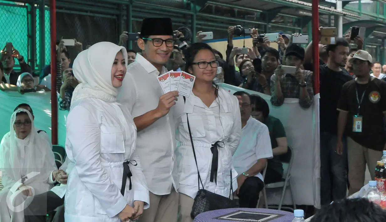 Calon Wakil Gubernur (Cawagub) DKI Jakarta, Sandiaga Uno bersama istri dan anaknya menunujukan kertas suara saat menggunakan hak pilihya dalam Pilkada Putaran kedua di TPS 01, Kebayoran Baru, Jakarta, Rabu (19/4). (Liputan6.com/Helmi Afandi)