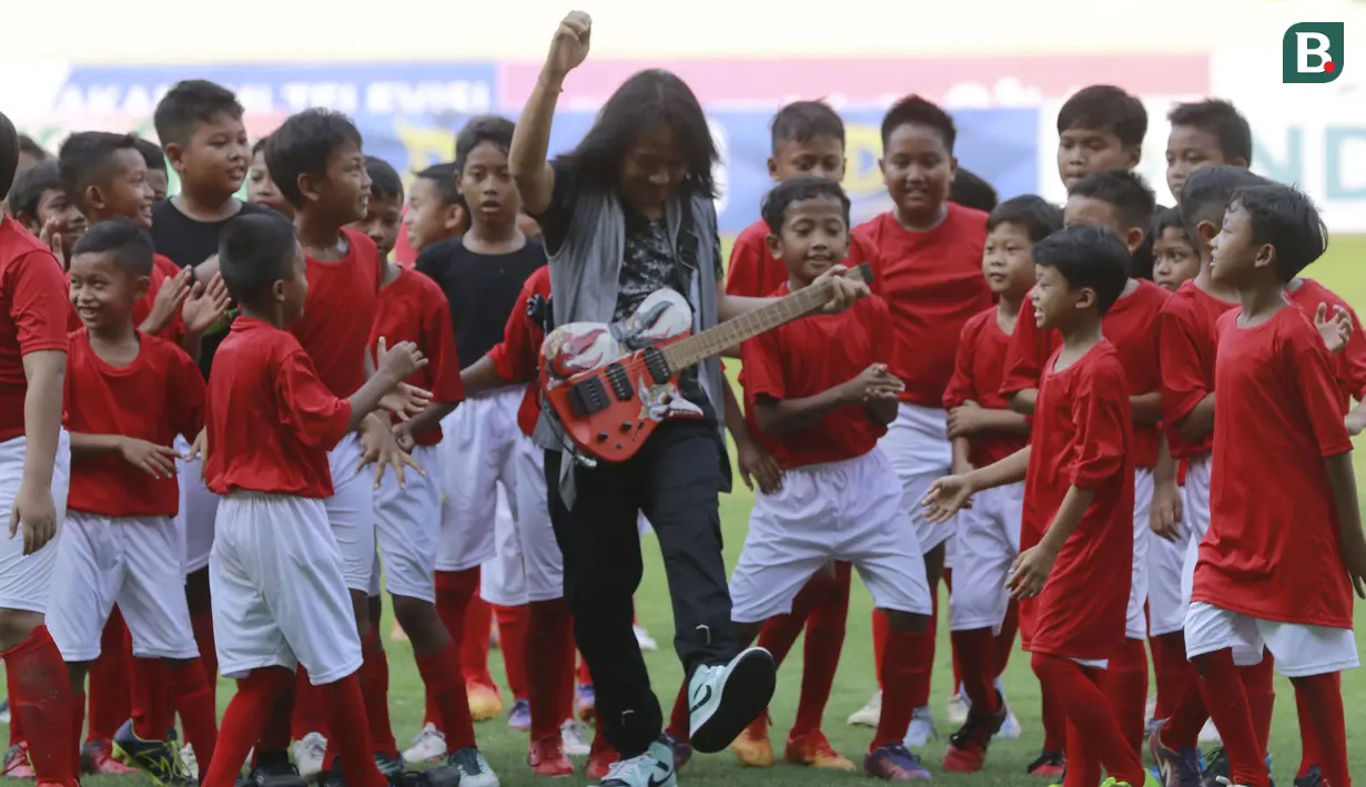Gitaris grup band GIGI, Dewa Bujana, saat beraksi dalam acara Pembukaan Piala Presiden 2022 di Stadion Manahan, Solo, Jawa Tengah, Sabtu (11/6/2022). (Bola.com/Arief Bagus)