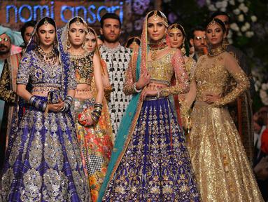 Para model mengenakan pakaian tradisional Pakistan rancangan desainer Nomi Ansari selama peragaan busana yang digelar oleh Loreal Paris Pakistan Fashion Design Council di Lahore, Selasa (4/9). (AP Photo / K.M Chaudary)