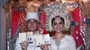 Akad nikah Nycta Gina dan Rizky Kinos. Pasangan yang telah resmi menjadi suami istri ini menunjukkan buku nikah mereka.  (Deki Prayoga/Bintang.com)