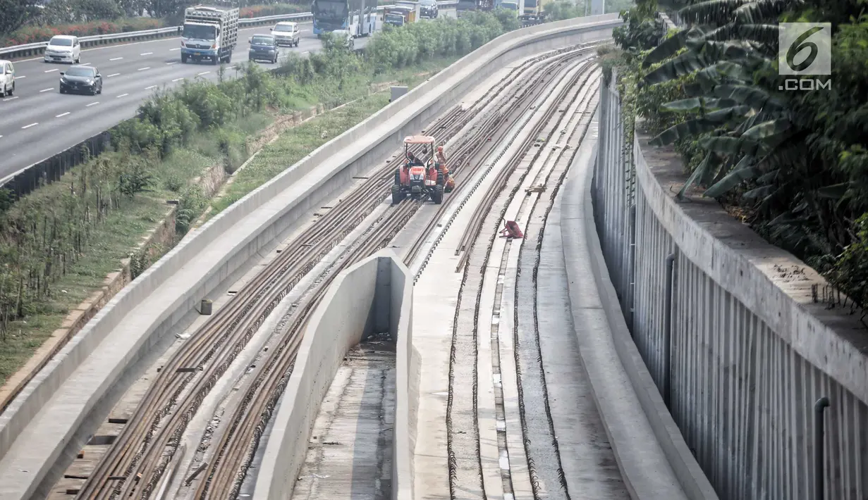 Pekerja terihat di pembangunan proyek kereta api ringan (light rail transit/LRT) di kawasan Kampung Makasar, Jakarta, Kamis (26/7). Secara keseluruhan, proyek kereta ringan atau LRT Jakarta telah rampung sekitar 85 persen. (Liputan6.com/Faizal Fanani)