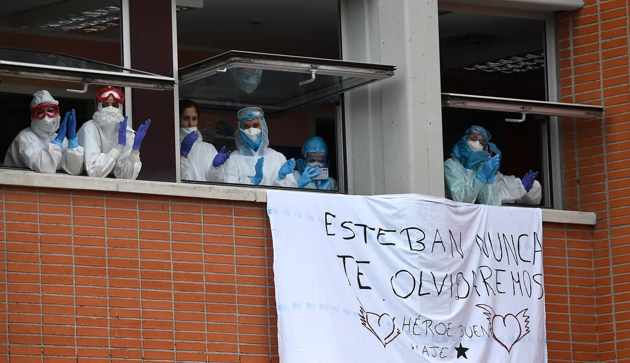 Petugas kesehatan bertepuk tangan untuk mengenang Esteban, perawat yang gugur karena virus corona COVID-19 di Rumah Sakit Severo Ochoa di Leganes, Spanyol, Jumat (10/4/2020). Hingga Minggu (12/4/2020) pagi, total kasus COVID-19 di Spanyol sebanyak 163.027. (Photo by PIERRE-PHILIPPE MARCOU/AFP)