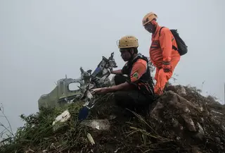 Personel tim pencarian dan penyelamatan melihat puing-puing pesawat turboprop Indonesia Air Transport berjenis ATR 42-500 di Gunung Bulusaraung, Sulawesi Selatan pada Minggu 18 Januari 2026. Tim gabungan terus mengoptimalkan operasi pencarian dan penyelamatan korban kecelakaan pesawat turboprop Indonesia Air Transport berjenis ATR 42-500 di Gunung Bulusaraung, Sulawesi Selatan. (Muchtamir Zaide/AFP)