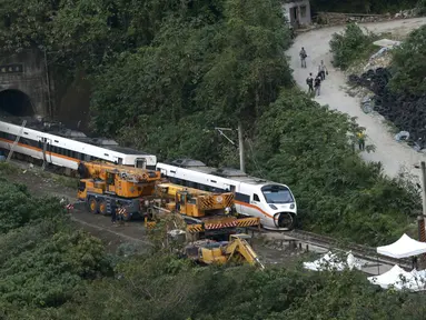 Petugas penyelamat memindahkan bagian dari kereta yang tergelincir dekat Ngarai Taroko di Hualien, Taiwan, Sabtu (3/4/2021). Badan Pemadam Kebakaran Nasional Taiwan melaporkan korban jiwa tabrakan kereta di Hualien bertambah hingga 50 orang dan melukai 66 lainnya. (AP Photo/Chiang Ying-ying)