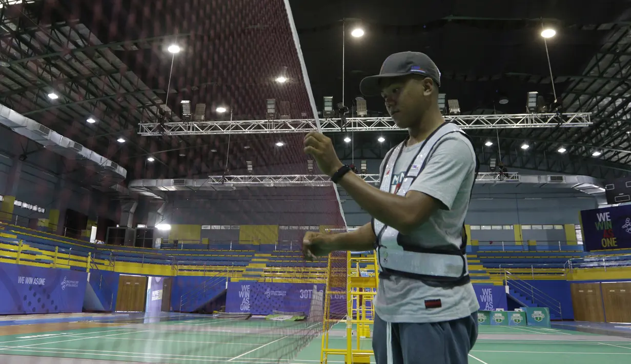 Pekerja menyelesaikan persiapan untuk venue bulutangkis SEA Games 2019 di Muntinlupa Sports Center, Manila, Sabtu (23/11). Cabang bulutangkis akan mulai bertanding pada Minggu (1/12). (Bola.com/M Iqbal Ichsan)