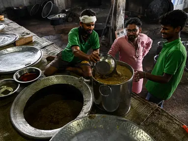 Koki katering menyiapkan hidangan bernama 'rebusan daging kambing Haleem' dalam peralatan besar untuk dijual kepada umat Muslim untuk berbuka puasa selama Ramadhan di Chennai (20/4/2022). Haleem adalah sajian favorit yang cukup populer, terutama saat bulan Ramadhan dan Muharram. (AFP/Arun Sankar)