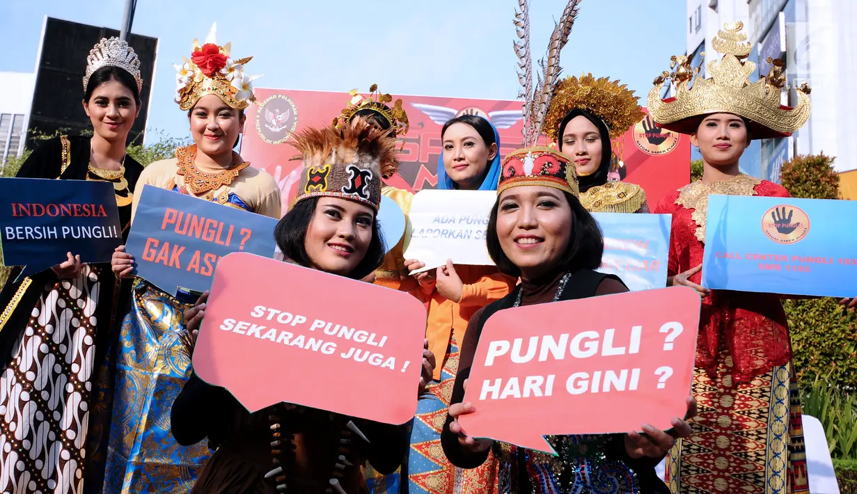 Petugas berpakaian adat daerah menunjukkan tulisan saat social community gathering Satgas Saber Pungli di Jakarta, Minggu (17/9). Kemenko Polhukam meluncurkan maskot dan melakukan sosialisasi satgas saber pungli. (Liputan6.com/Helmi Fithriansyah) 