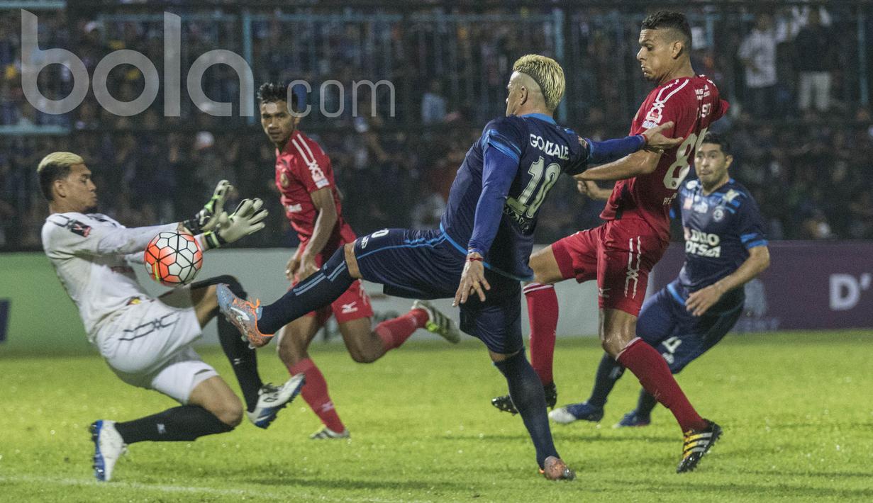 Striker Arema FC, Cristian Gonzales, berusaha membobol gawang Semen Padang yang dijaga Muhammad Ridwan. Akhirnya perjuangan Singo Edan membuahkan hasil, mereka berbalik unggul menjadi 5-2 atas tamunya Kabau Sirah. (Bola.com/Vitalis Yogi Trisna)